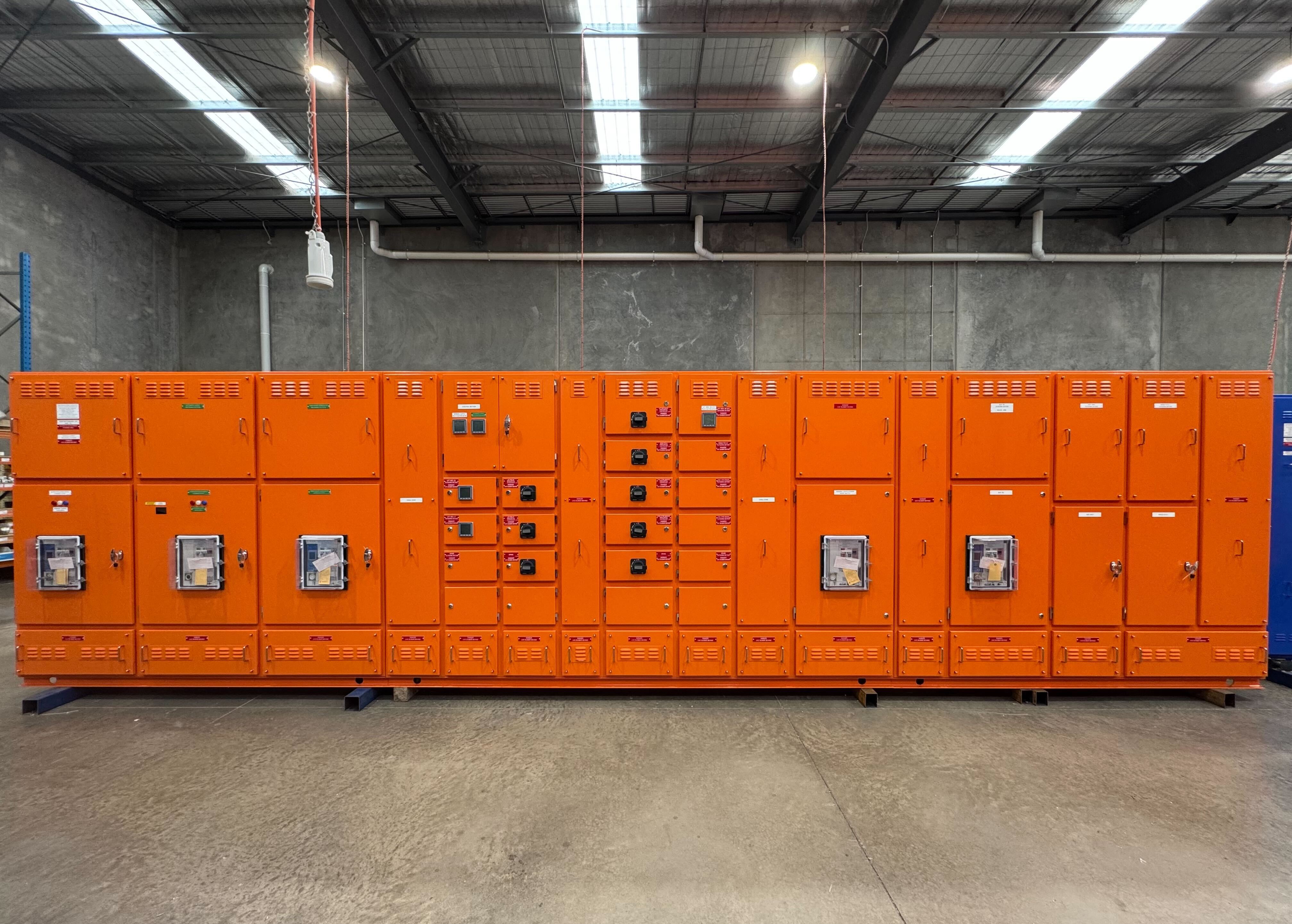 Row of orange main switchboards manufactured by RMS Manufacturing
